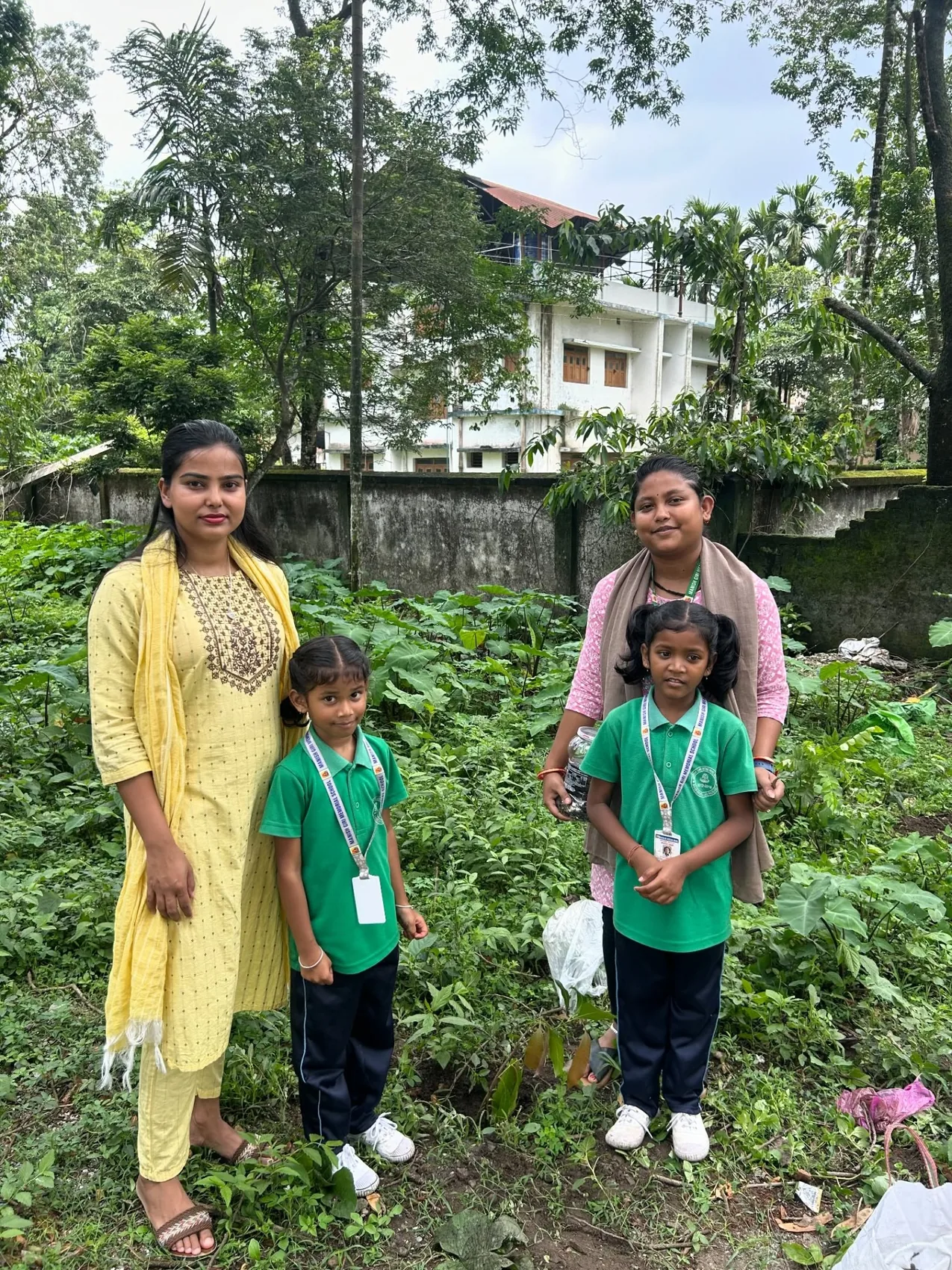 Two MGM teachers and two pupils visiting an outdoor green area